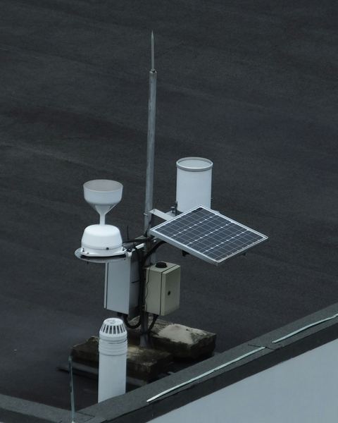 A rooftop monitoring station with weather sensors powered by a small solar panel